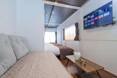 a bedroom with a bed and a tv on the wall at PremiumStay Komagome in Tokyo
