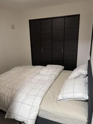 a bed with a black headboard and two white pillows at Mark\u7684\u8db3\u7acb\u6c11\u5bbf in Tokyo