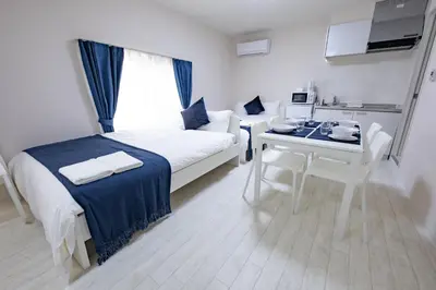 a room with a bed and a table and a kitchen at iine house hatagaya in Tokyo