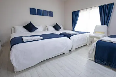 a bedroom with two beds and a window at iine house hatagaya in Tokyo