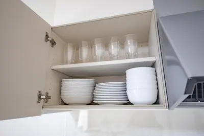a cupboard filled with plates and bowls at iine house hatagaya in Tokyo