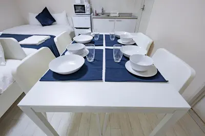 a white dining room table with white dishes on it at iine house hatagaya in Tokyo