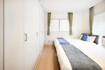 a bedroom with two beds and a window at Simple Stay ShibuyaShinjyuku in Tokyo