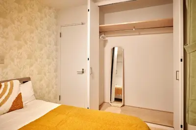 a bedroom with a bed and a mirror at Simple Stay ShibuyaShinjyuku in Tokyo