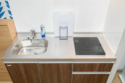 a kitchen counter with a sink and a box of cleaning products at Mori hotel Akihabara 1 in Tokyo