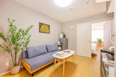 a living room with a blue couch and a table at Mori hotel Akihabara 1 in Tokyo