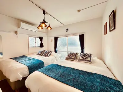 two beds in a room with two windows at Hotel Axel Shinjuku in Tokyo