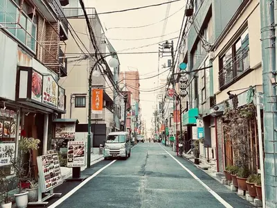 a van driving down a city street with buildings at Hotel Axel Shinjuku in Tokyo