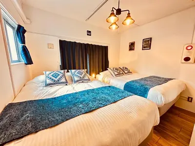 two beds in a room with a window at Hotel Axel Shinjuku in Tokyo