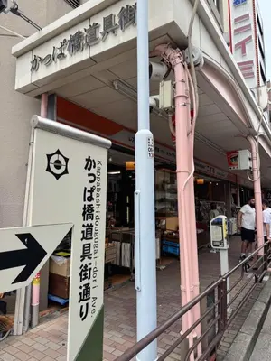 a store with an arrow sign in front of a building at househotel\u4e0a\u91ce \u5165\u8c37 in Tokyo