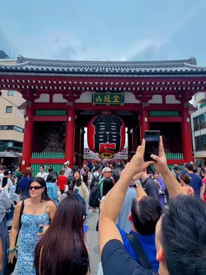 a crowd of people taking pictures in front of a building at househotel\u4e0a\u91ce \u5165\u8c37 in Tokyo