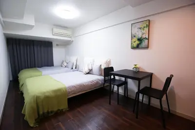 a bedroom with a bed and a desk and a table at \u6b4c\u821e\u4f0e\u753a\u306e\u96a0\u308c\u5bb6 \u65b0\u5bbf\u30a8\u30ea\u30a2\u89b3\u5149\u306b\u4fbf\u5229Qo4 in Tokyo