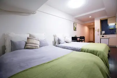 two beds sitting next to each other in a room at \u6b4c\u821e\u4f0e\u753a\u306e\u96a0\u308c\u5bb6 \u65b0\u5bbf\u30a8\u30ea\u30a2\u89b3\u5149\u306b\u4fbf\u5229Qo4 in Tokyo