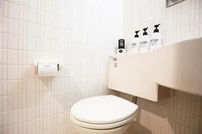 a white bathroom with a toilet and a sink at \u6b4c\u821e\u4f0e\u753a\u306e\u96a0\u308c\u5bb6 \u65b0\u5bbf\u30a8\u30ea\u30a2\u89b3\u5149\u306b\u4fbf\u5229Qo4 in Tokyo
