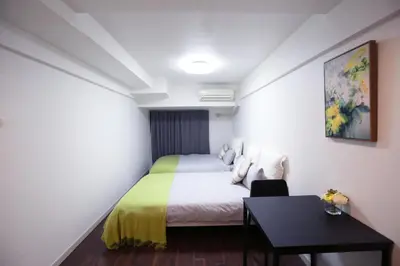 a small bedroom with a bed and a table at \u6b4c\u821e\u4f0e\u753a\u306e\u96a0\u308c\u5bb6 \u65b0\u5bbf\u30a8\u30ea\u30a2\u89b3\u5149\u306b\u4fbf\u5229Qo4 in Tokyo