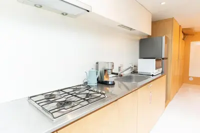 a kitchen with a stove top oven next to a microwave at \u6c60\u888b\u8fd1\u304f\u5e83\u3005\u5feb\u9069\u306a\u4e00\u8ed2\u5bb6unbound in Tokyo