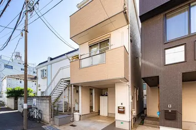 an apartment building with a staircase in front of it at Fit-Inn Komagome JR Line and Komagome 2 min walk Direct access to Shinjuku Ikebukuro Shibuya Akihabara Ueno in Tokyo