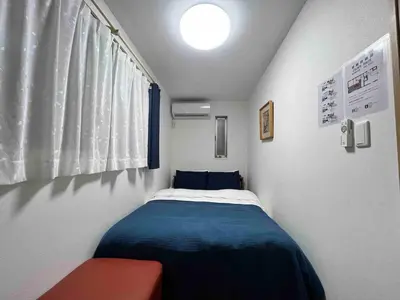 a small bedroom with a bed and a window at Fit-Inn Komagome JR Line and Komagome 2 min walk Direct access to Shinjuku Ikebukuro Shibuya Akihabara Ueno in Tokyo