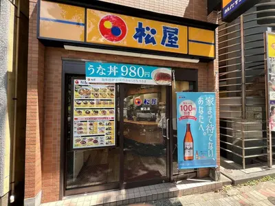 a restaurant with a sign on the side of a building at Fit-Inn Komagome JR Line and Komagome 2 min walk Direct access to Shinjuku Ikebukuro Shibuya Akihabara Ueno in Tokyo