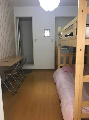 a bedroom with a bunk bed and a desk and a table at \u65b0\u5bbf\u6771\u4eac\u6696\u623f in Tokyo