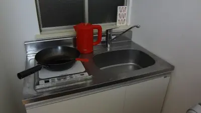 a kitchen counter with a frying pan on a stove at \u65b0\u5bbf\u6771\u4eac\u6696\u623f in Tokyo