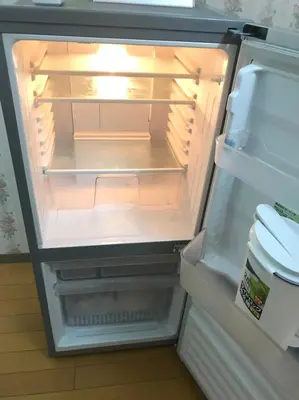 an open refrigerator with its door open and its lights on at \u65b0\u5bbf\u6771\u4eac\u6696\u623f in Tokyo