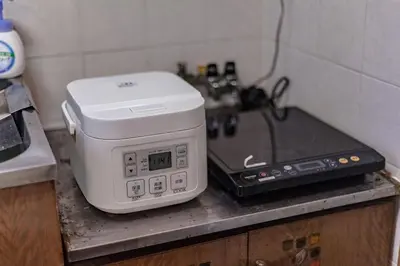 a microwave sitting on a counter next to a laptop at \u30b9\u30de\u30a4\u30eb\u30cf\u30a6\u30b9 in Tokyo