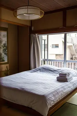 a bed in a bedroom with a large window at Bright Park House in central Tokyo in Tokyo