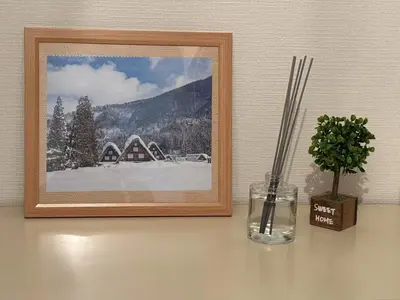 a picture on a wall with a vase and a plant at \u5409\u5c4b-\u65b0\u5bbf in Tokyo