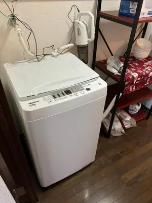 a white washing machine sitting next to a shelf at \u5409\u5c4b-\u65b0\u5bbf in Tokyo