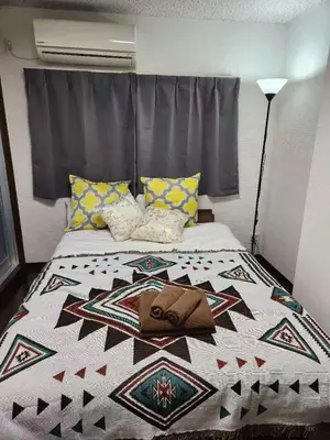 a bedroom with a bed with a quilt on it at \u5409\u5c4b-\u65b0\u5bbf in Tokyo