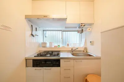 a small kitchen with a sink and a stove at Sakura House Meguro in Tokyo