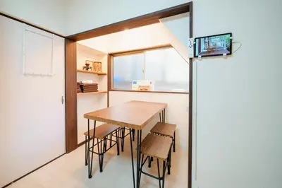 a small kitchen with a wooden table and chairs at Sakura House Meguro in Tokyo