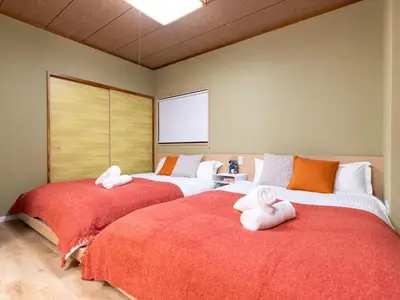 two beds in a room with towels on them at \u6d45\u8349\u8907\u5f0f\u516c\u5bd3 \u6c11\u5bbf \u6700\u592710\u4eba \u6d45\u8349 \u6d45\u8349\u5bfa in Tokyo