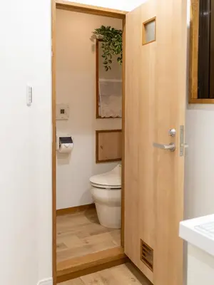 a bathroom with a toilet and a wooden door at \u6d45\u8349\u8907\u5f0f\u516c\u5bd3 \u6c11\u5bbf \u6700\u592710\u4eba \u6d45\u8349 \u6d45\u8349\u5bfa in Tokyo