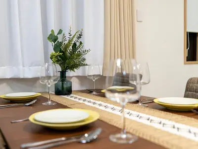 a dining table with yellow plates and glasses on it at \u6d45\u8349\u8907\u5f0f\u516c\u5bd3 \u6c11\u5bbf \u6700\u592710\u4eba \u6d45\u8349 \u6d45\u8349\u5bfa in Tokyo