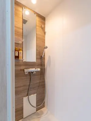 a shower in a bathroom with a mirror at \u6d45\u8349\u8907\u5f0f\u516c\u5bd3 \u6c11\u5bbf \u6700\u592710\u4eba \u6d45\u8349 \u6d45\u8349\u5bfa in Tokyo