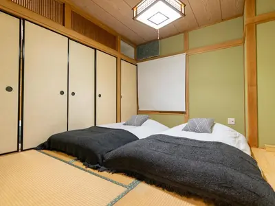 a bedroom with two beds and a chandelier at \u6d45\u8349\u8907\u5f0f\u516c\u5bd3 \u6c11\u5bbf \u6700\u592710\u4eba \u6d45\u8349 \u6d45\u8349\u5bfa in Tokyo