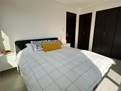 a bedroom with a large bed with a yellow pillow at Mark\u7684\u8db3\u7acb\u6c5f\u5317\u7ad9\u6c11\u5bbf in Tokyo