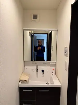 a person taking a picture of a bathroom sink at Mark\u7684\u8db3\u7acb\u6c5f\u5317\u7ad9\u6c11\u5bbf in Tokyo