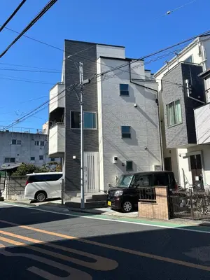 two cars parked on a street in front of a building at Mark\u7684\u8db3\u7acb\u6c5f\u5317\u7ad9\u6c11\u5bbf in Tokyo