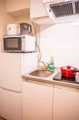 a small kitchen with a microwave and a sink at \u548c\u306e\u5bbf\u30db\u30c6\u30ebYamatoinn Akihabara#101 in Tokyo