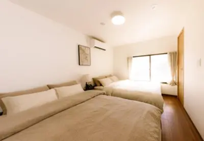 a bedroom with two beds and a window at Moon Hotel in Tokyo