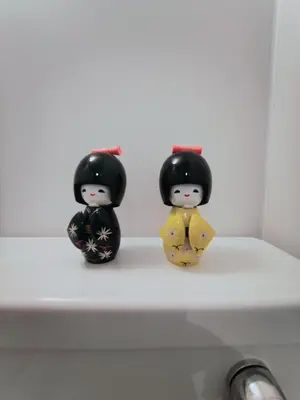 three dolls sitting on top of a white shelf at Moon Hotel in Tokyo