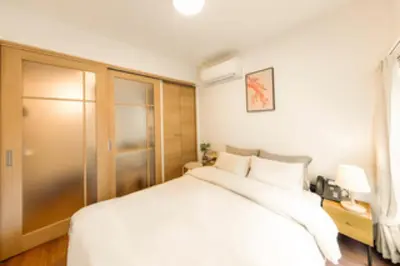 a bedroom with a large white bed and a window at Moon Hotel in Tokyo