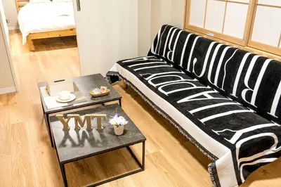 a living room with a black and white couch and a table at \u548c\u306e\u5bbf\u30db\u30c6\u30ebYamatoinn Akihabara#201 in Tokyo