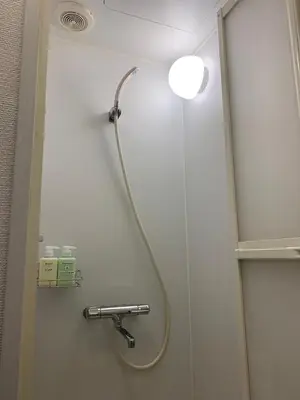 a shower with a hose attached to a wall at HOTEL PRELE Shinkan \u30db\u30c6\u30eb\u30d7\u30ec\u30fc\u30eb\u65b0\u9928 in Tokyo