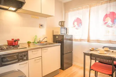 a kitchen with a sink and a refrigerator and a table at \u548c\u306e\u5bbf\u30db\u30c6\u30ebYamatoinn Akihabara#301 in Tokyo
