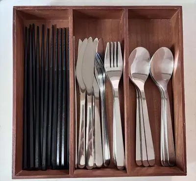 a wooden box filled with forks knives and spoons at Ueno new villa in Tokyo