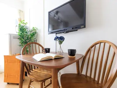 a wooden table with a book and a tv on a wall at Skytree 13 minute drive Exclusive whole home stay in Tokyo